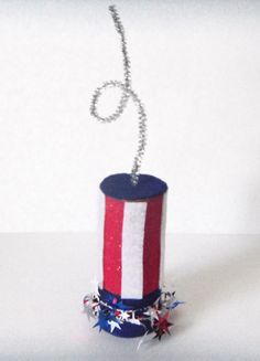 a red, white and blue hat with stars on it is hanging from a chain