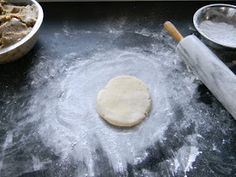 the dough is being made on the counter with other ingredients nearby, including an uncooked pizza crust