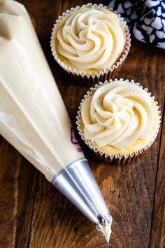 two cupcakes with frosting being piped into the icing on top