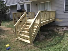 a wooden staircase next to a house in the grass