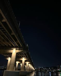 an underpass at night with lights reflecting in the water