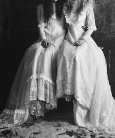 two women in long dresses sitting next to each other