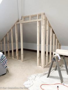 an unfinished attic is being worked on with tools and construction materials in the foreground