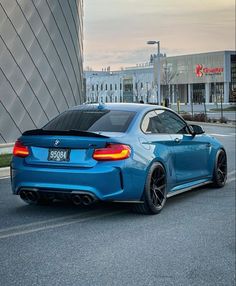 a blue bmw car parked in front of a building