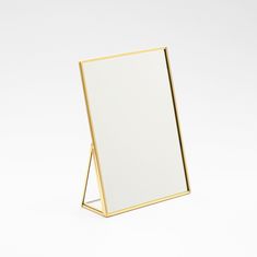 a white and gold framed mirror sitting on top of a table