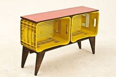 a yellow sideboard with two baskets on it's legs and a red top