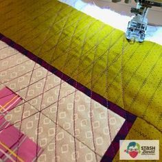 a close up of a sewing machine with some fabric on the table next to it