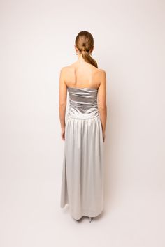 An exquisite maxi dress with a bandeau style that will elevate your fashion game. The dress features a beautiful two tone fabric detail and a flattering drop waist that accentuates your figure. The ruche effect on top adds a touch of elegance, while the full maxi skirt adds a flowy and feminine touch to the overall look. 97% Polyester, 3% Elastane Hand wash Silver Maxi Dress, Metallic Trousers, Full Maxi Skirt, Drop Waist Dress, Satin Maxi, Satin Maxi Dress, Dropwaist Dress, Halterneck Dress, Style Maxi Dress