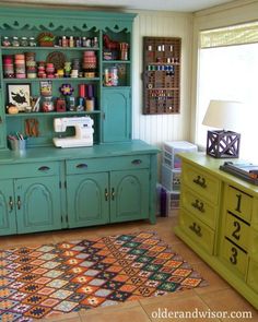 a room with green cabinets and rugs on the floor