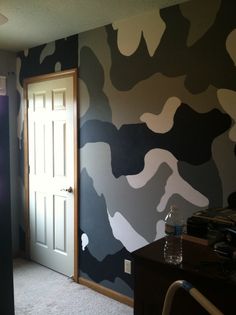 an empty room with camouflage wallpaper and door