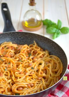 a pan filled with spaghetti and sauce on top of a table