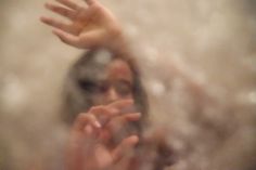 a blurry image of a woman's hands in front of a mirror