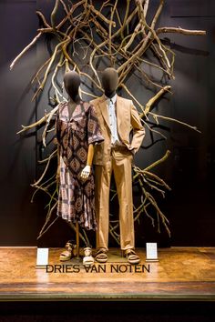 two mannequins dressed up in formal clothing stand next to each other on display