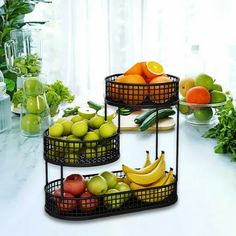 three tiered baskets filled with fruit on top of a counter next to vegetables and fruits