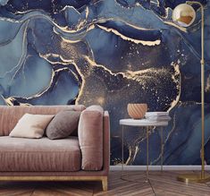 a living room scene with a couch, table and wallpaper that has gold paint on it