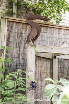 a metal bird sitting on top of a wooden door