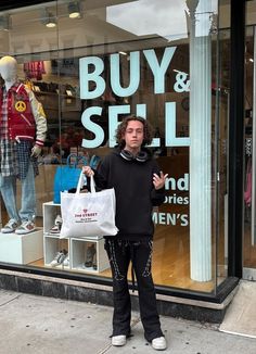 a man standing in front of a store window with his hand up to the camera