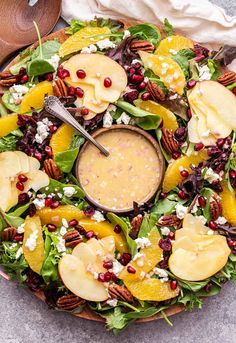 a salad with oranges, pecans and feta cheese on top is served in a bowl