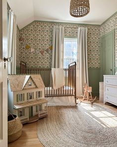 a baby's room with a crib, rocking chair and toy house on the rug