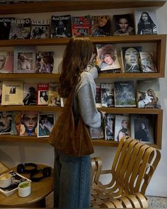 a woman standing in front of a book shelf filled with books