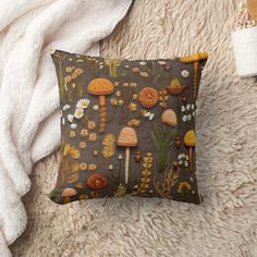 a pillow with mushrooms and flowers on it