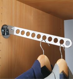 a pair of clothes hanging from a metal hook on a wooden closet door with two hangers