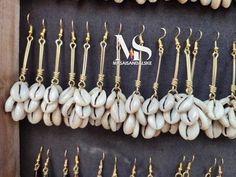 10 Well crafted  brass and bone earrings.  All same design  same sweet feeling with cowrie shell.  Wholesale price available up to a thousand pairs. Place your order thank you Cowrie Earrings, Rope Earrings, Cowrie Shell Earrings, Cowrie Shell Jewelry, Dope Jewelry Accessories, Bone Earrings, Wholesale Earrings, Cowrie Shells, Funky Earrings