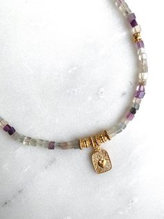 DAFNE NECKLACE Fluorite beaded necklace with gold plated details and heart pendant Dimensions: Total necklace length  40cm / 15.74 in + 5cm / 1.96in  extender chain Weight: 20gr DELIVERY (estimate delays) Greece: 2-5 business days via ELTA  Europe: 5-10 business days via Hellenic Post International: 10-21 business days via Hellenic Post You can shorten considerably your delivery times by upgrading to DHL Express services at checkout.  All PURE GREEK Jewels  are inspired from the ancient greek arts, folklore traditions and world cultures. Our jewelry are handmade with love and imagination so you can enjoy unique creations.   I use mineral and semi-precious stones, crystals, real pearls,  gold plated brass metal, wooden elements, greek and oriental charms, pompons and feathers. I only use hi Spiritual Gemstone Beads Necklace, Adjustable Gold Beaded Necklace With Heart Charm, Gold Shell Necklace With Gemstone Beads As Gift, Spiritual Gemstone Charm Necklaces, Fluorite Gemstone Beads Necklace For Gifts, Semi Precious Stone Jewelry, Healing Fluorite Pendant Necklace, Heishi Necklace, Fluorite Necklace