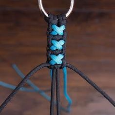 a close up of a blue and black rope with a metal hook attached to it