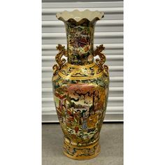 an ornate vase is sitting in front of a garage door