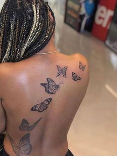 the back of a woman's shoulder with butterflies on it