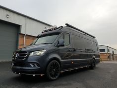 a black mercedes van parked in front of a building