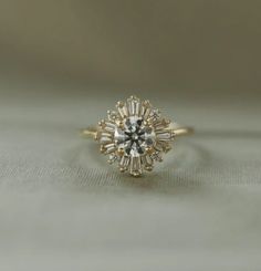 an engagement ring is shown on a white surface, with the center stone surrounded by small diamonds