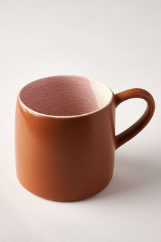 a brown cup sitting on top of a white table