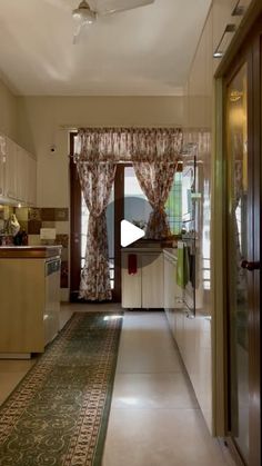 a long hallway leading to a kitchen and dining room