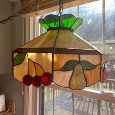 a stained glass lamp hanging from a window