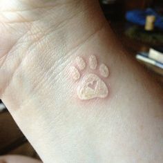 a person with a paw tattoo on their wrist