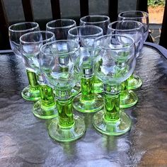 green wine glasses lined up on a table