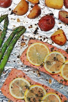 salmon, potatoes and asparagus on tin foil with lemons in the background