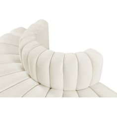 an upholstered white leather sofa with pleated back and armrests, viewed from the side