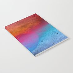 a notebook with an abstract painting on the front and back cover that is multicolored