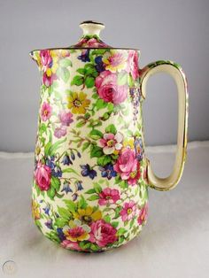 a tea pot with flowers painted on it