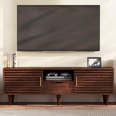 a flat screen tv mounted to the side of a wooden entertainment center in a living room