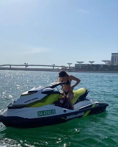 a woman sitting on top of a jet ski in the water