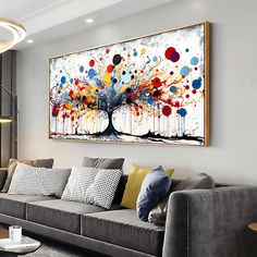 a living room filled with furniture and a large painting on the wall above it's couch