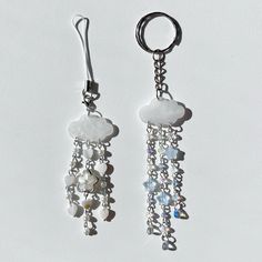 two pairs of dangling earrings with white beads and crystal stones, on a white background