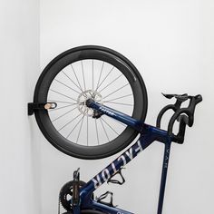 there is a bike hanging on the wall with it's tire in front of it