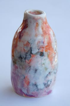 a colorful vase sitting on top of a white table