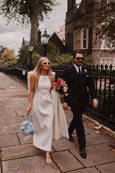 a bride and groom walking down the street