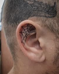 a man with a spider web tattoo on his ear